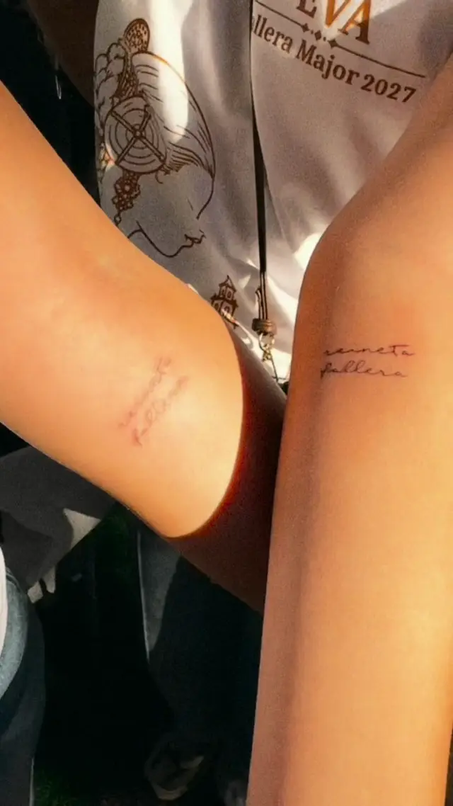 Mini tattoos al aire libre en una fiesta de pueblo: falleras enseñando sus tatuajes recién hechos y Alba tatuando en la mesa